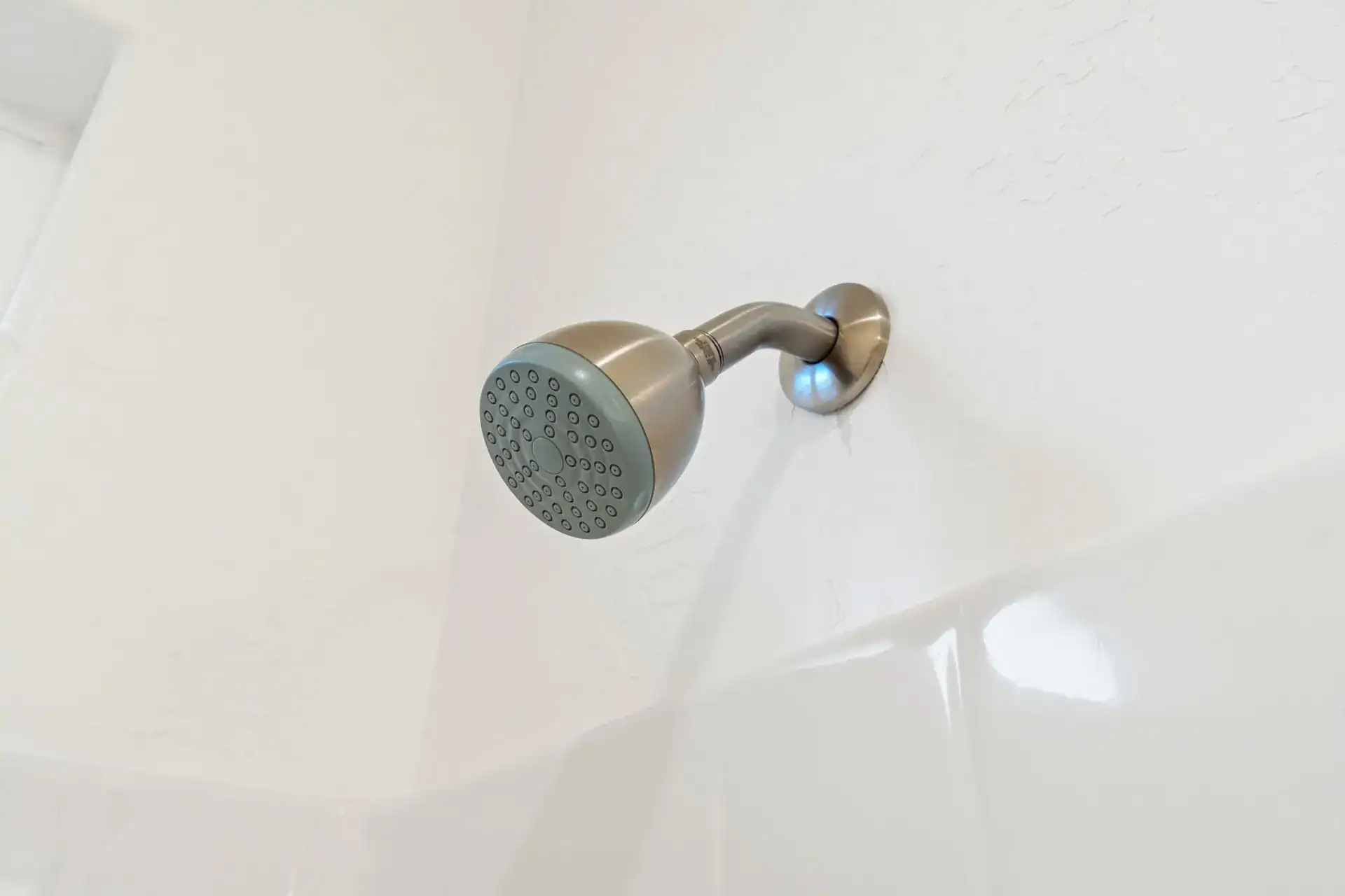 Showerhead mounted on a white bathroom wall, ready for use.