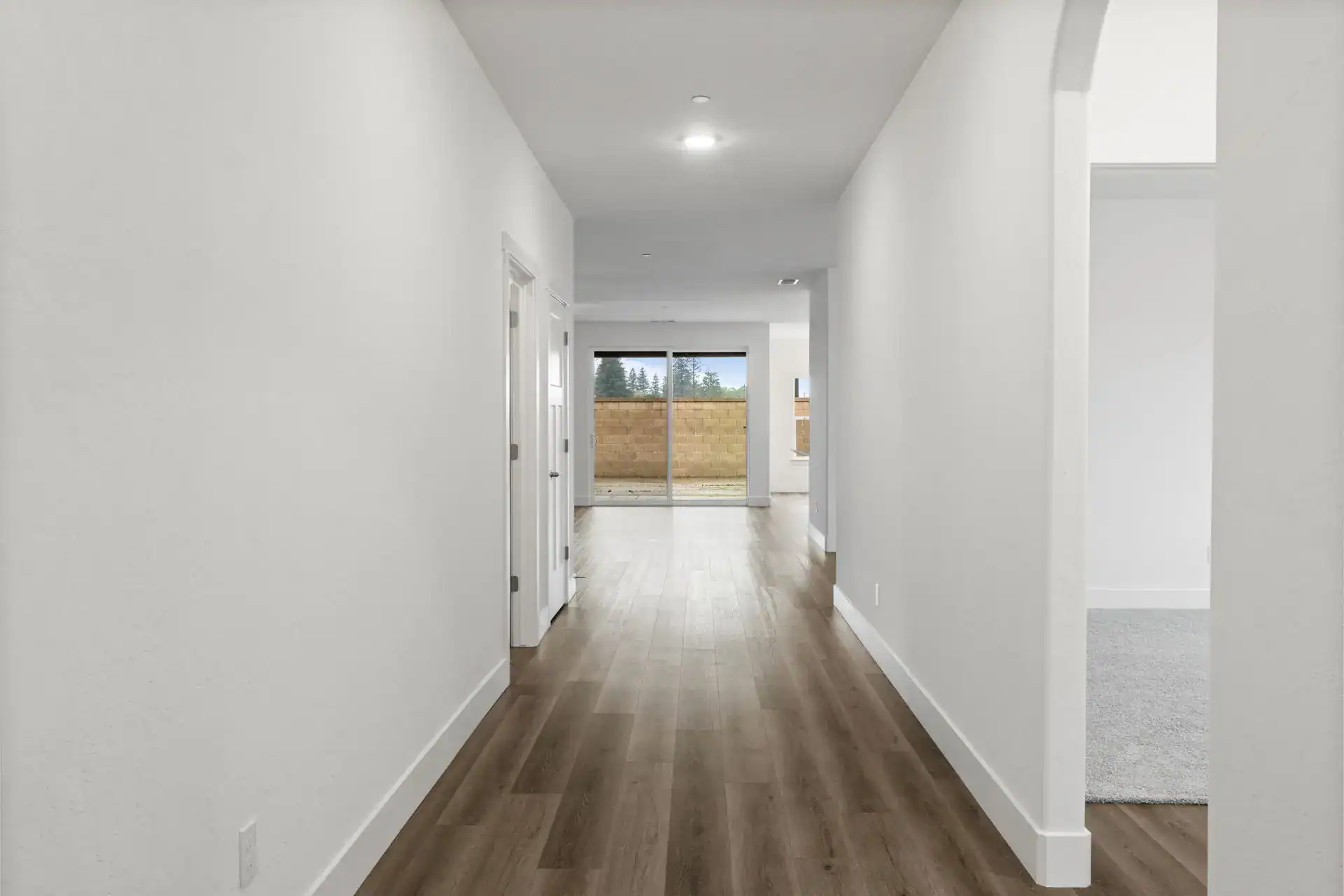 Interior hallway with white walls and wooden flooring in a modern home.