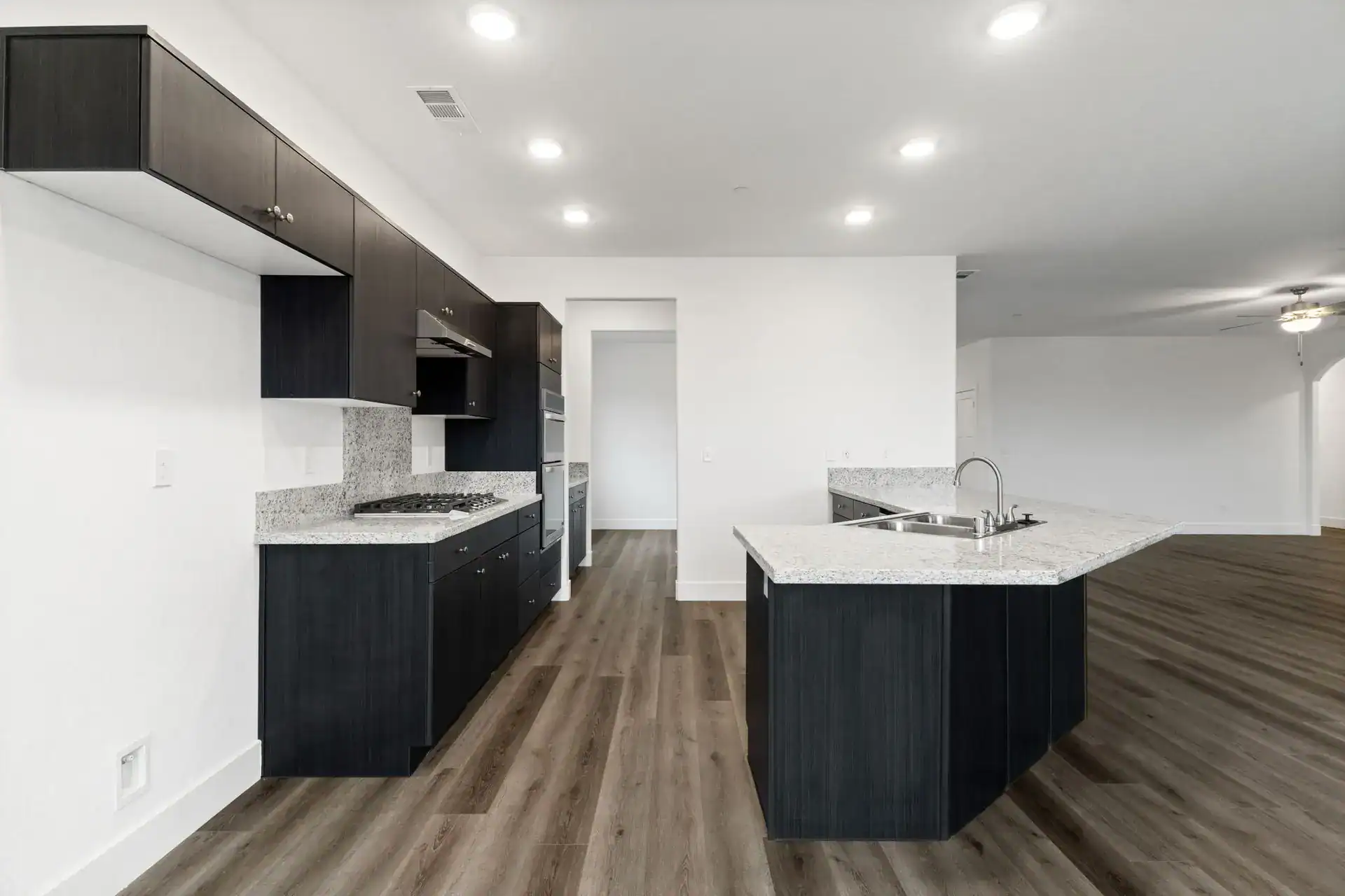 Spacious kitchen featuring dark cabinetry, granite countertops, and modern appliances for a stylish.