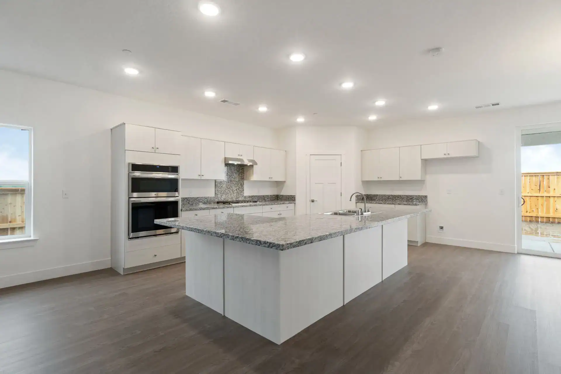 Bright, spacious kitchen featuring a large island, white cabinets, and stainless steel appliances.