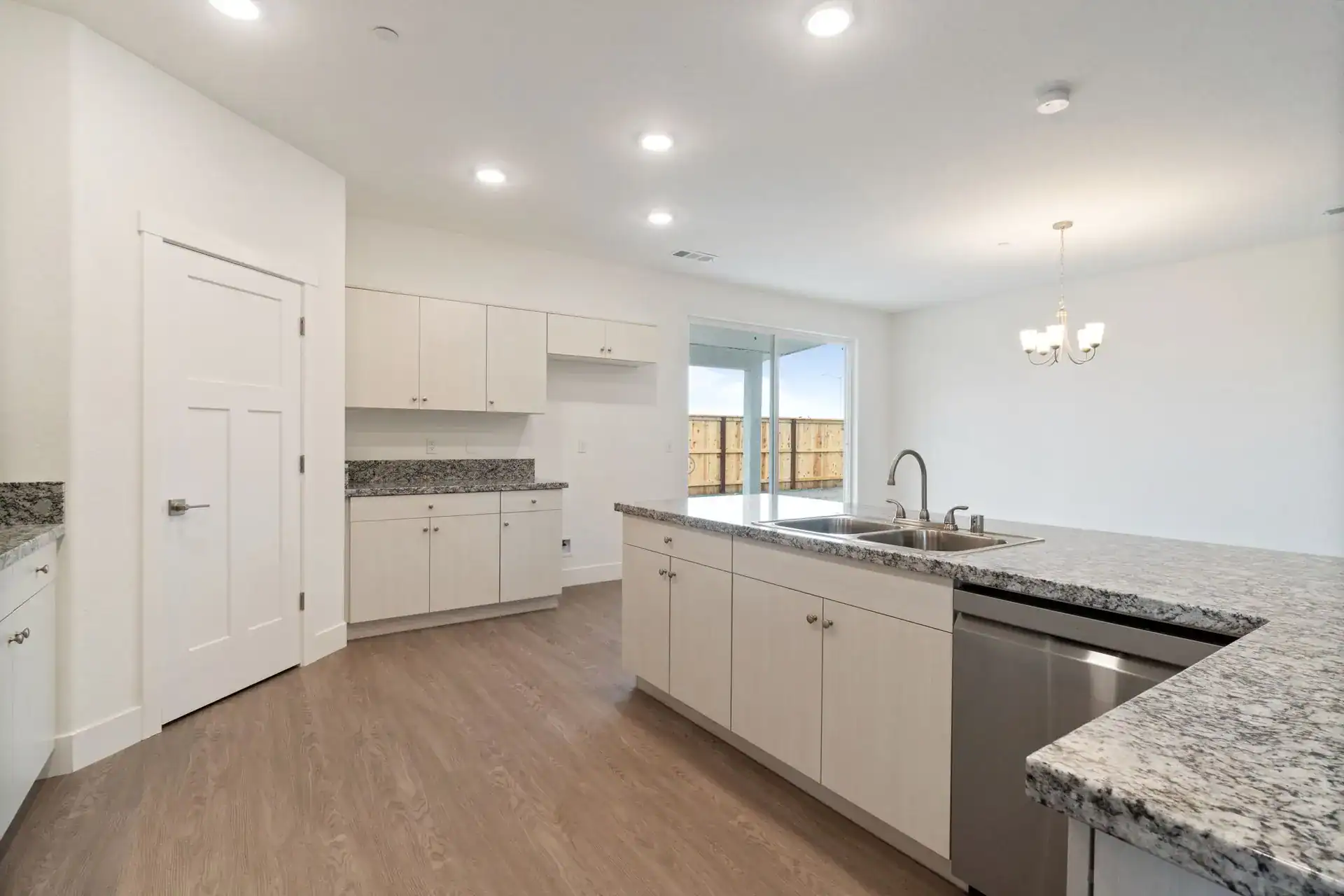Modern kitchen with white cabinets and granite countertops.