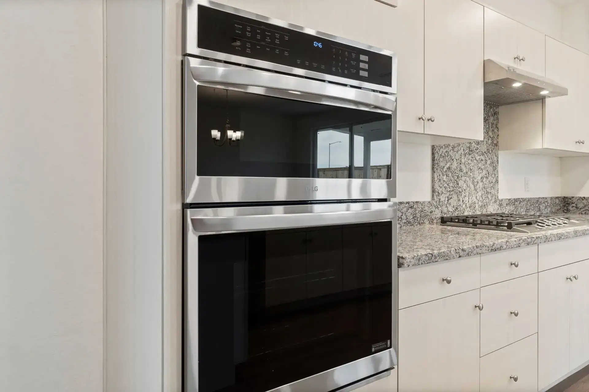 Stainless steel double oven in a modern white kitchen setting.