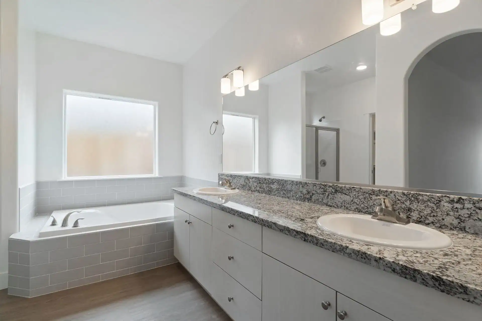 Bathroom with double sink, granite countertop, and natural light.